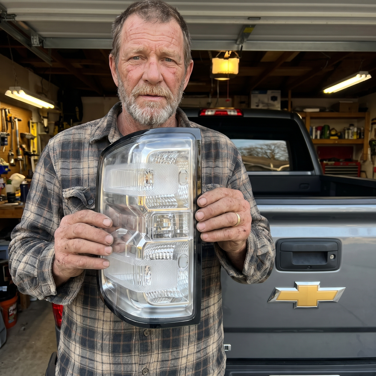 Clear Silverado tail light held in front of the truck
