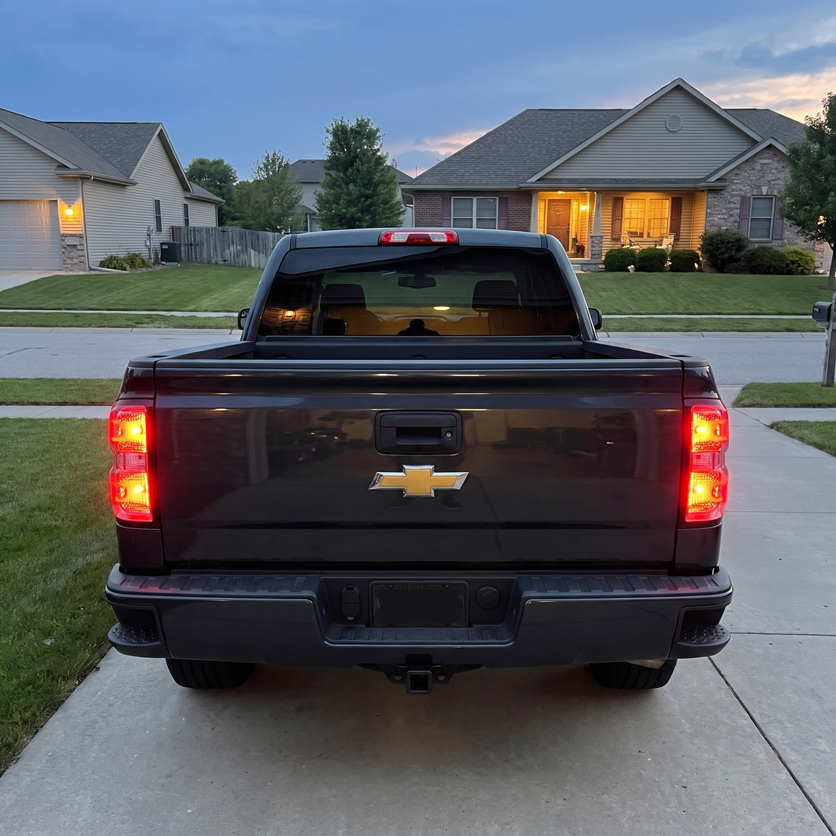 Silverado with clear tail lights lit red at dusk